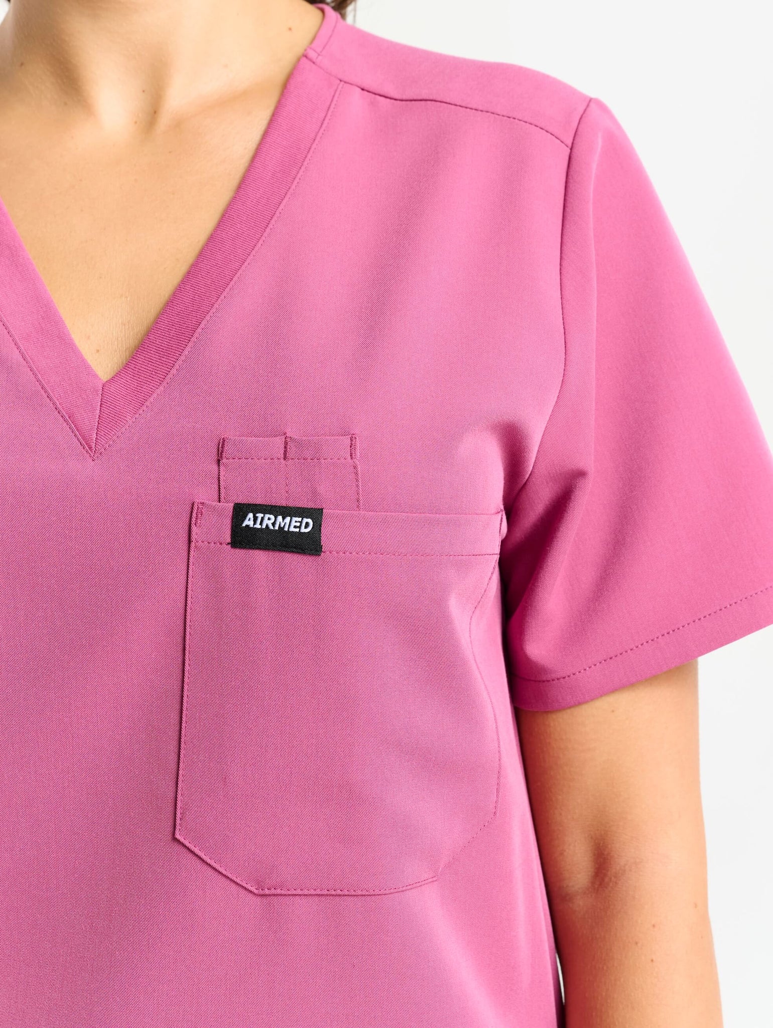 close up of sleeve detail of red violet one pocket v neck scrub top