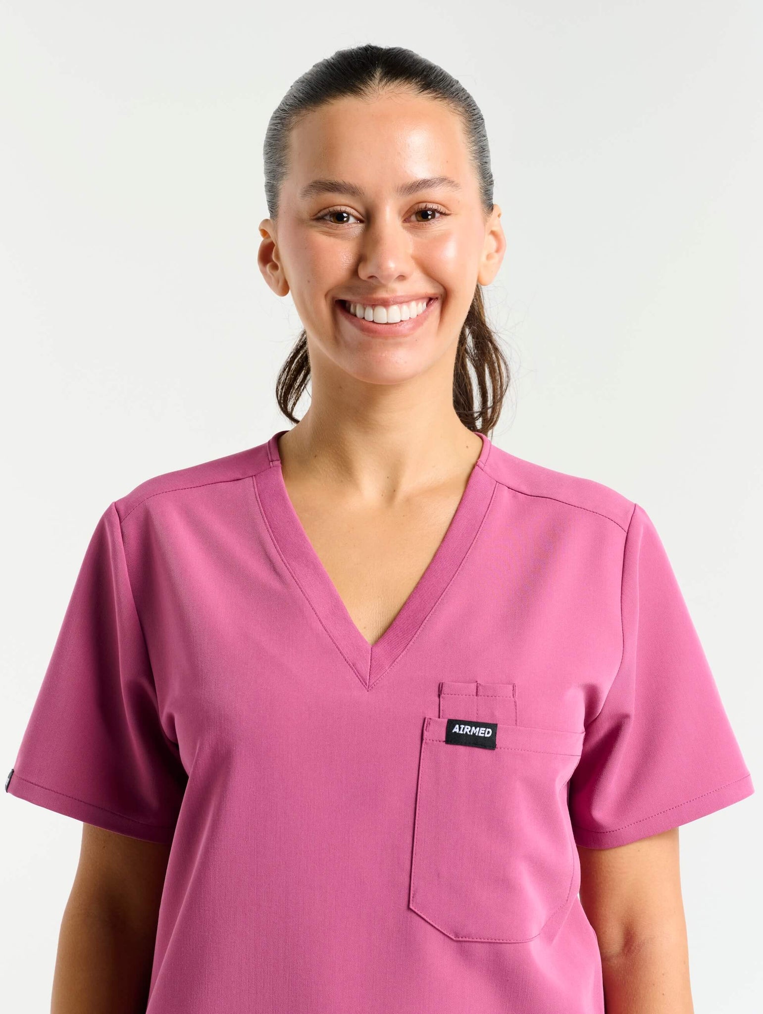 close up of hem detail of red violet one pocket v neck scrub top