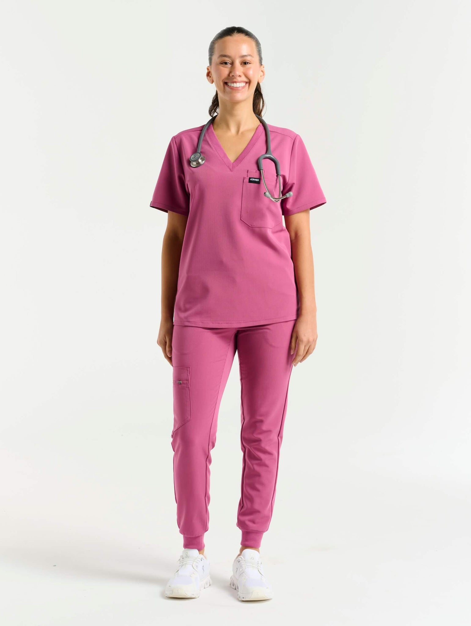 front view with stethoscope of red violet one pocket v neck scrub top